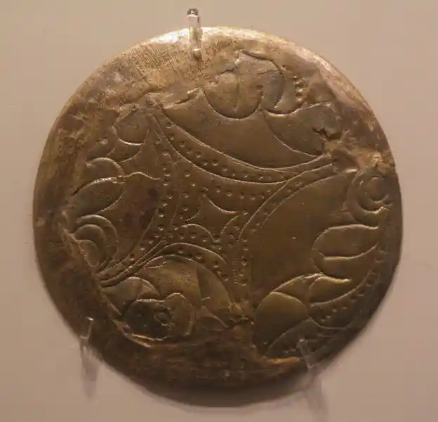 Diamond-like cross engraved on a circular metal sheet